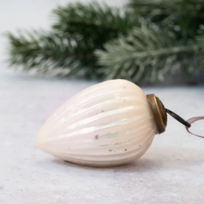 2" Alba Glass Pinecone Christmas Ornament with a ribbed design, bronze cap, and pink organza ribbon, displayed next to a frosted pine branch on a neutral background.