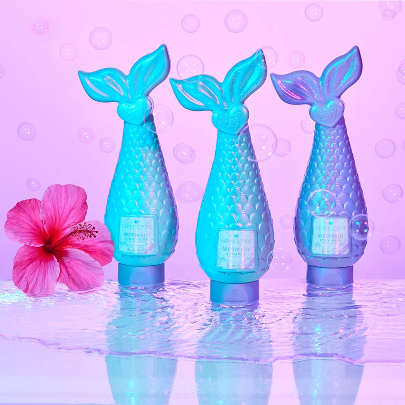 Three blue mermaid tail bottles with a pink flower on a purple background