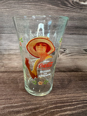 Vintage Coca Cola Magnificent Ladies Collector Series 1 Glasses featuring vibrant images of women in classic Coca-Cola advertising on a wooden surface.