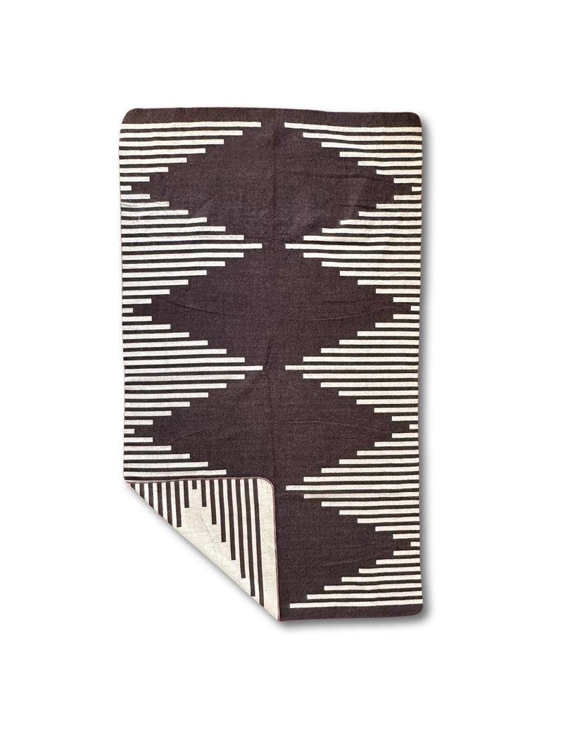 Folded Coffee alpaca throw highlighting the minimalist dark brown and cream diamond/zigzag pattern.