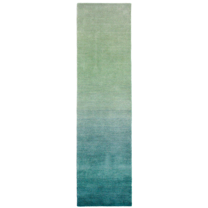 A luxurious blue ombre indoor rug measuring 5'x7'6", made of 100% hand-loomed wool with a sophisticated contemporary design.