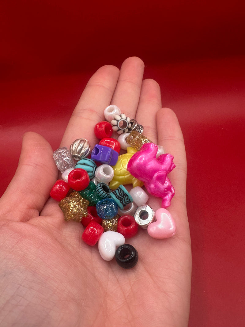 Hand holding colorful assorted plastic beads for friendship bracelets