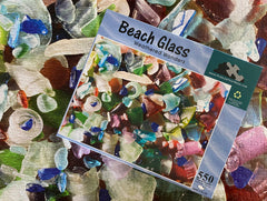 Multiple views of the Beach Glass jigsaw puzzle, including the box, completed puzzle, and bonus insert.