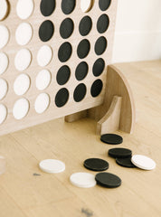 Wooden game board with black and white discs on a wooden surface