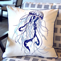 Blue Jellyfish Embroidered Throw Pillow displayed on a patterned chair indoors, showcasing its intricate coastal design.