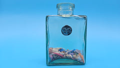 Glass bottle featuring butterfly emblem and colorful shell fill – cottagecore and coastal decor
