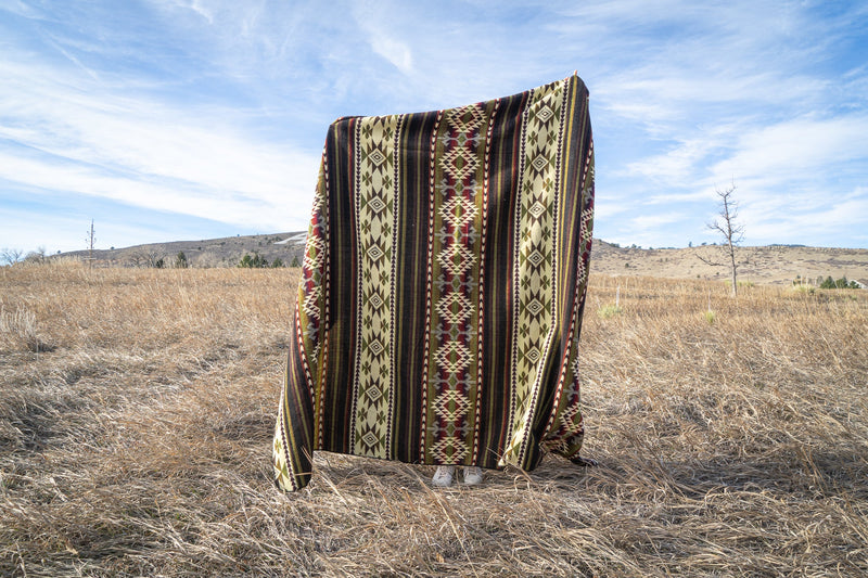 Close side-view of the Cactus Alpaca Blanket draped, focusing on the vibrant color stripes and geometric details.