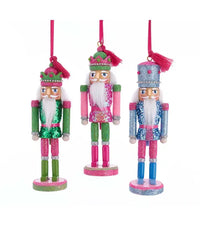 Three colorful nutcracker ornaments on a white background