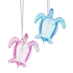 Two acrylic turtle decorations, one pink and one blue, on a white background.