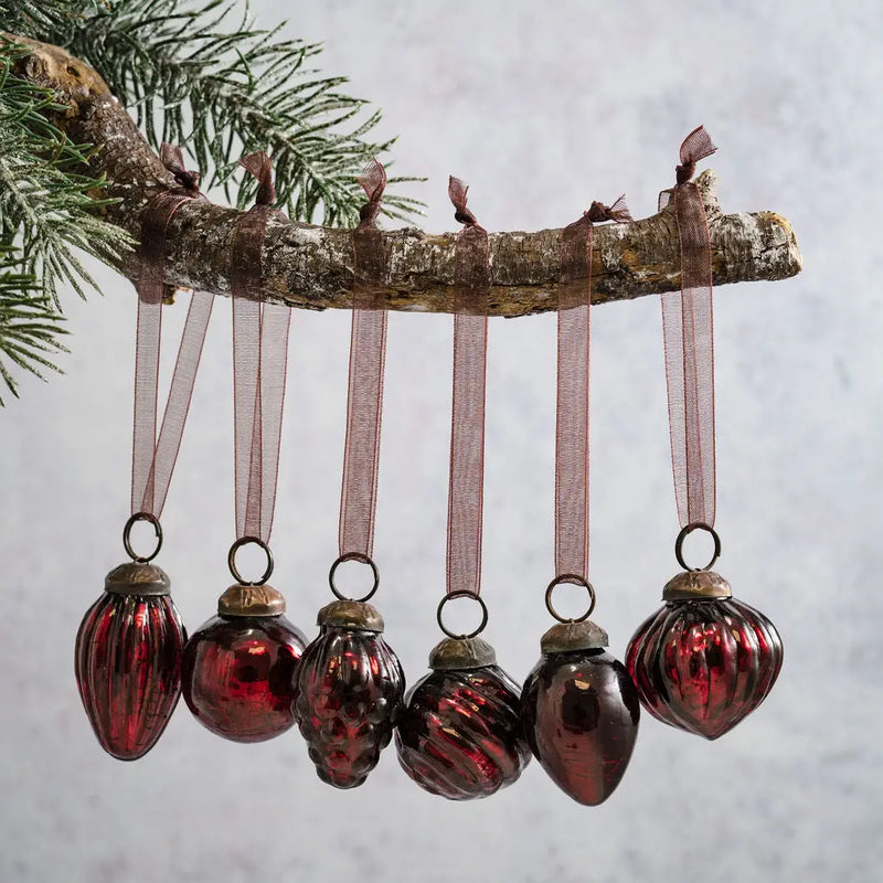 Set of 6 small 1-inch wine crackle glass ornaments with different designs hanging from a branch