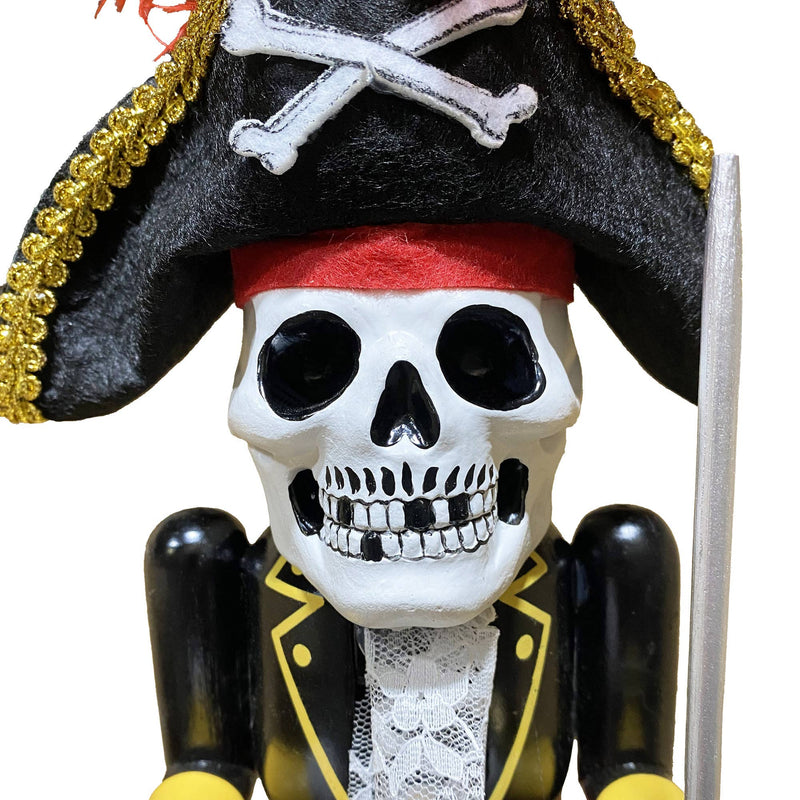 Close-up of skeleton-faced pirate nutcracker with red feather and skull-and-crossbones hat