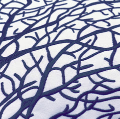 Close-up of the embroidered fan coral pattern on the pillow, highlighting the detailed multi-blue threadwork.