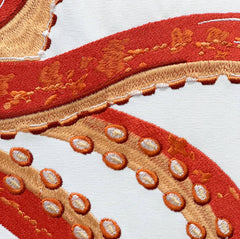 Close-up of the Coral Octopus Pillow showcasing the intricate embroidery details of the octopus tentacles in coral and orange tones.