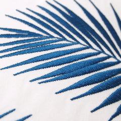 Close-up of the intricate blue palm embroidery on the Palm Pattern Lumbar Pillow, highlighting the detailed stitching.