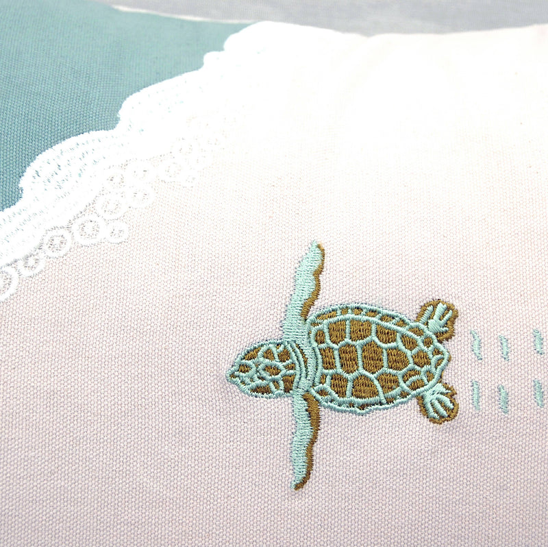 Close-up of the intricate baby turtle embroidery on the Turtle Migration Pillow, highlighting its detailed craftsmanship.