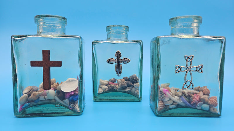 Coastal-style glass decor with cross symbol and natural shell fill – religious accent piece