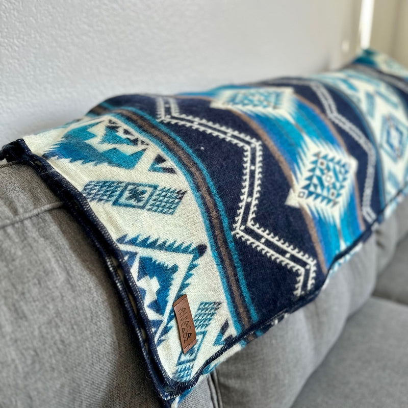 Side view of the Cobalt Blue Alpaca Blanket folded, revealing the thickness and the clean edge of the pattern.