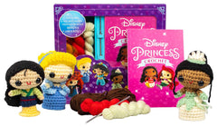Crocheted Disney Princess dolls with yarn and a crochet hook on a white background