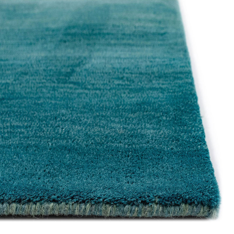 A luxurious blue ombre indoor rug measuring 5'x7'6", made of 100% hand-loomed wool with a sophisticated contemporary design.