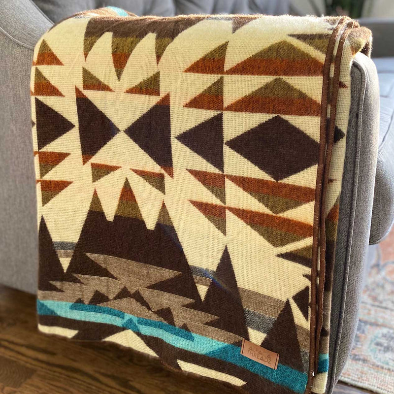 Close-up of the Cowboy reversible Alpaca Wool Blanket, folded to showcase the full, intricate geometric pattern and contrasting colors.