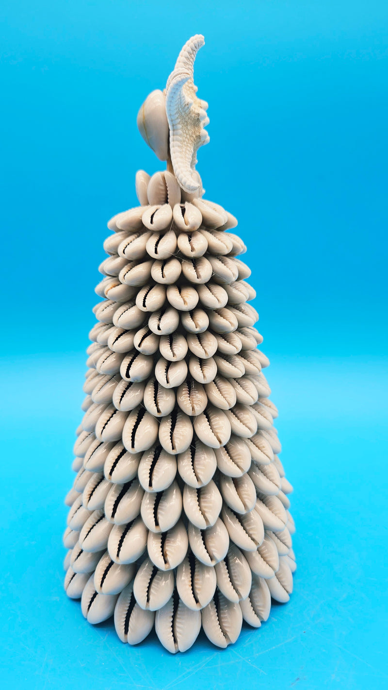 Detail shot of the individual cowrie shells layered on the conical coastal Christmas tree decor.