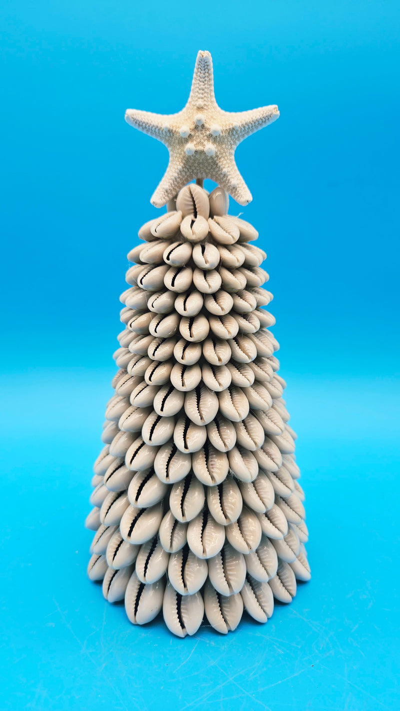 Handcrafted Cowrie Shell Christmas Tree with natural white starfish topper on a blue background.