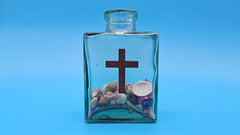 Christian decorative bottle with cross emblem and ocean shells – spiritual gift idea