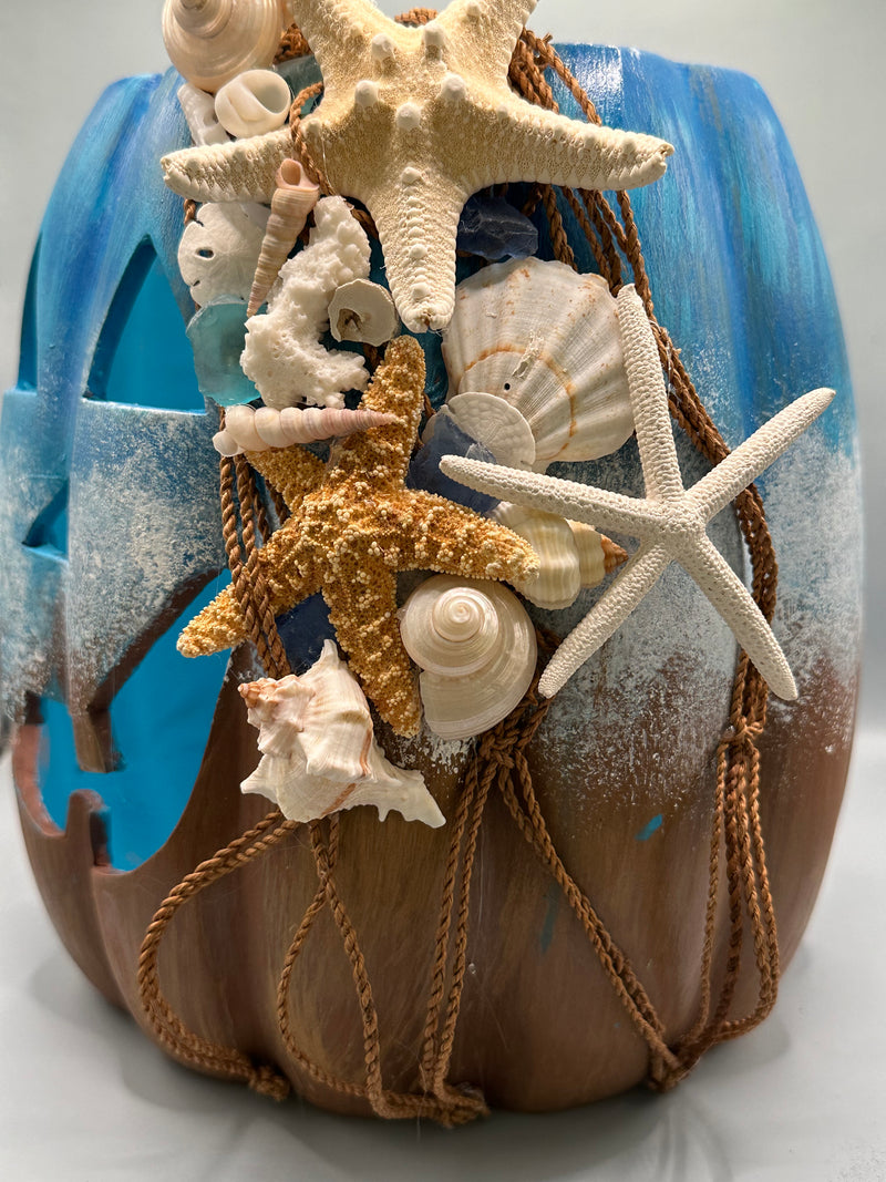 Side view showing seashells and starfish arranged on the edge of the Jack-O-Lantern.