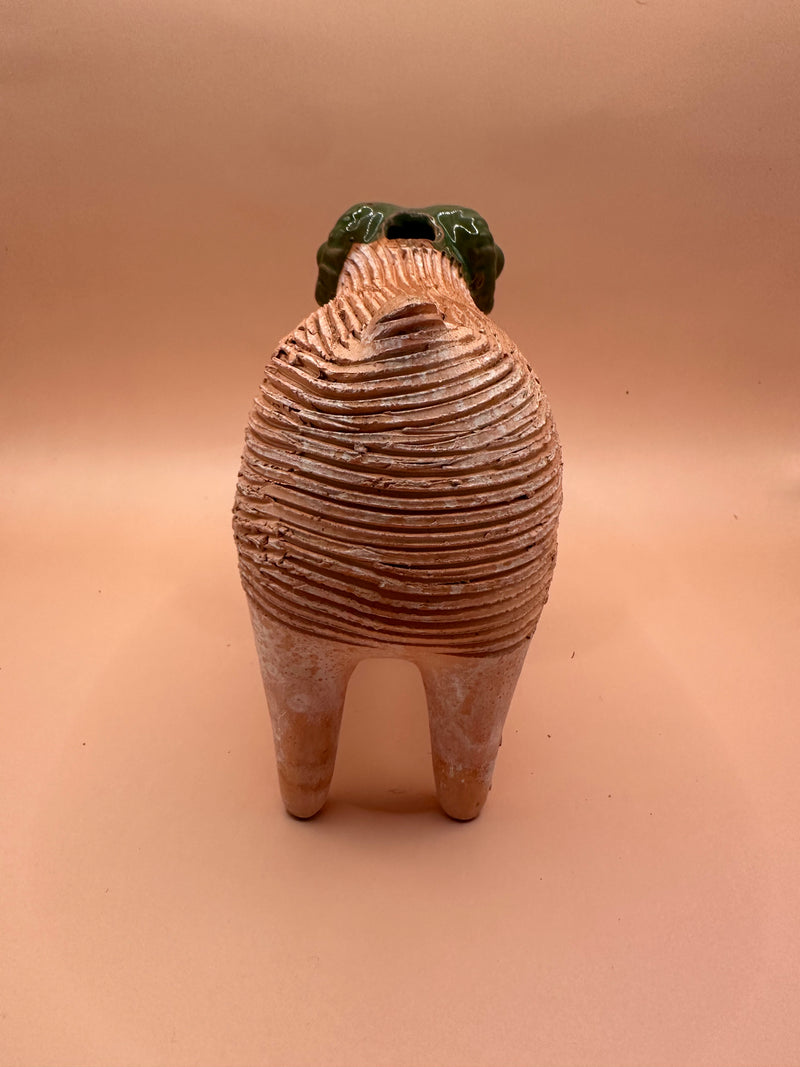 Back view of a vintage terra cotta ram chia pet, highlighting the textured body and four sturdy legs.