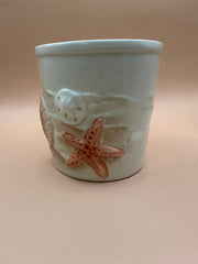 Side view of Vintage Shell Ceramic Planter showing embossed starfish and sand dollar designs.