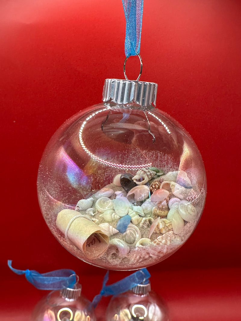 Glowing beach-themed glass ornaments filled with miniature shells, sand, and rolled messages