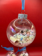 Glowing beach-themed glass ornaments filled with miniature shells, sand, and rolled messages