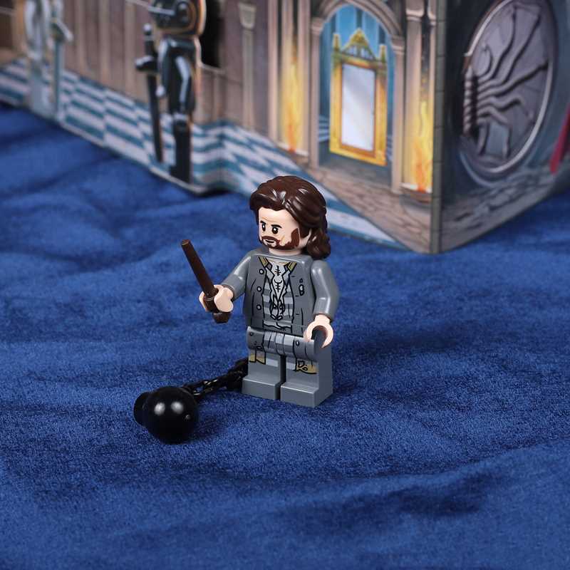 LEGO figure of a character holding a wand on a blue fabric background