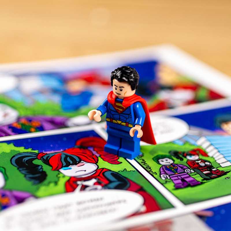 Superman minifigure on a children's coloring book with colorful illustrations.