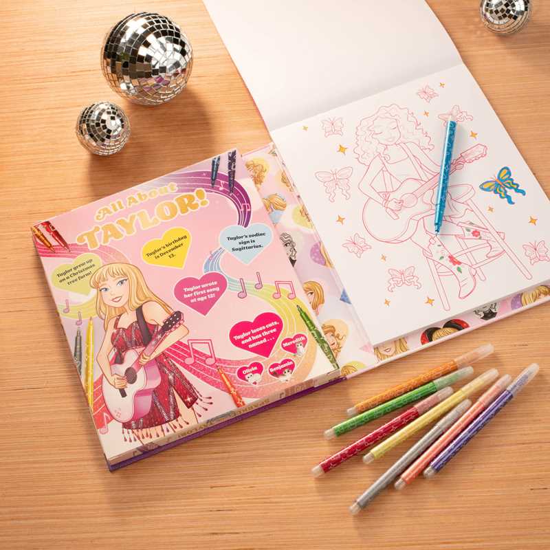 Coloring book with 'All About Taylor!' design on a wooden surface with coloring pencils.