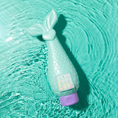 Mermaid Conditioner bottle lying on glossy aqua background showing creamy conditioner texture.