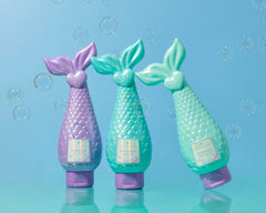 Mermaid Shampoo bottles in aqua, pink, and lavender shades displayed together on teal background.