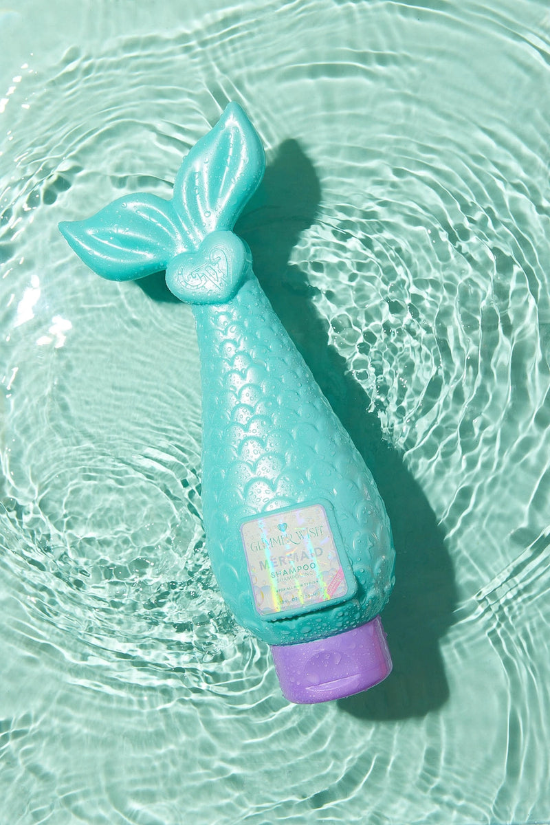 Mermaid Shampoo bottle lying on glossy aqua background showing creamy texture.