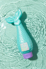 Mermaid Shampoo bottle lying on glossy aqua background showing creamy texture.