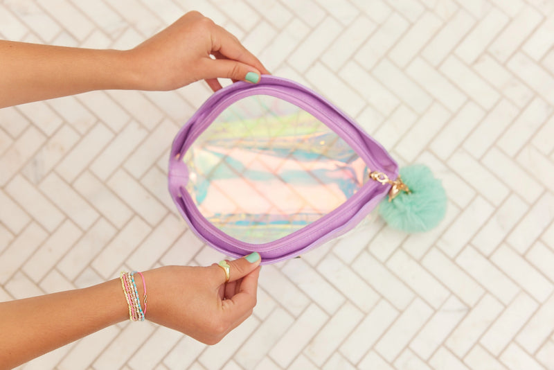 Person holding iridescent Mermaid Shell Cosmetics Bag showing shimmer and shell shape.