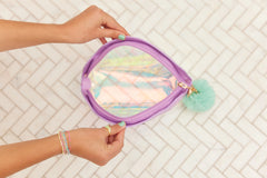 Person holding iridescent Mermaid Shell Cosmetics Bag showing shimmer and shell shape.