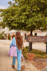 Group of girls walking together carrying Mermaid Shell Overnight Bags and matching accessories.