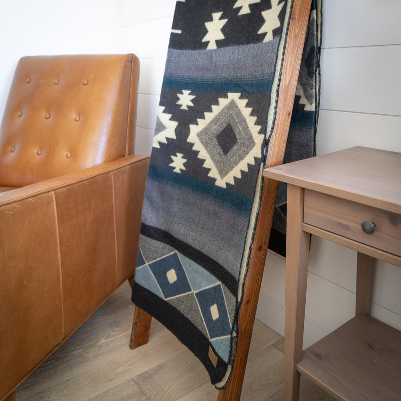 Detailed close-up of the geometric diamond motifs on the Midnight Blue & Grey Blanket, showing the contrast and the leather tag.