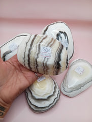 Polished natural onyx shell bowls with layered cream, gray, and brown tones
