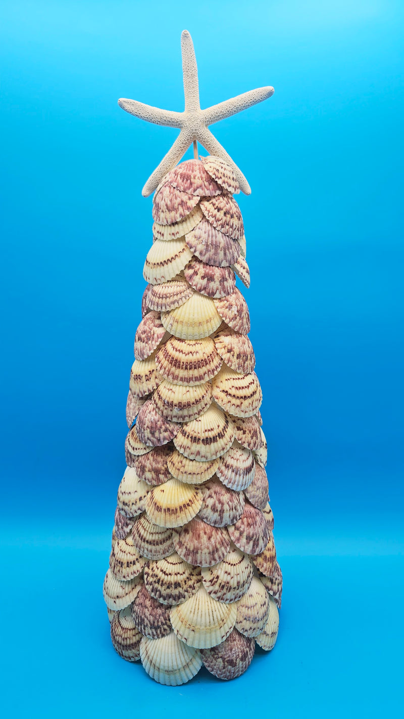 Handcrafted seashell tree decorated with layers of natural tan, brown, and pink patterned shells, topped with a white starfish, set against a bright blue background.