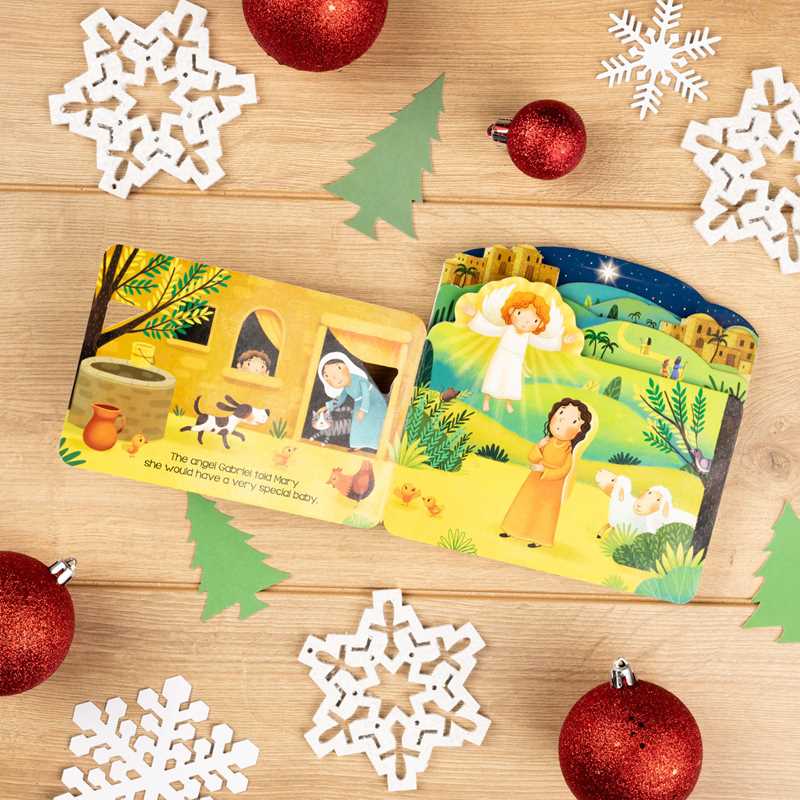 Children's books on a wooden surface with Christmas decorations