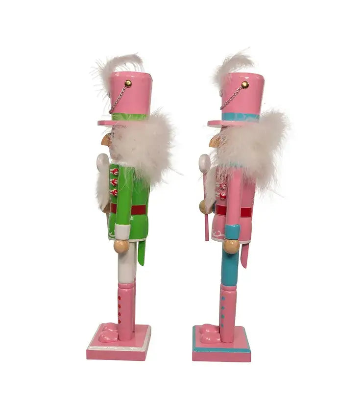 Two nutcrackers in pink and green outfits on a white background