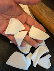 Handful of tumbled vintage milk glass pieces.