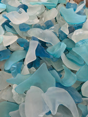 A pile of hand-tumbled frosted seaglass in blue, aqua, and clear colors, perfect for coastal decor.