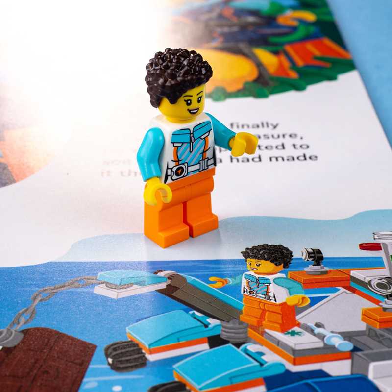 LEGO figure with a blue shirt and orange pants on a map